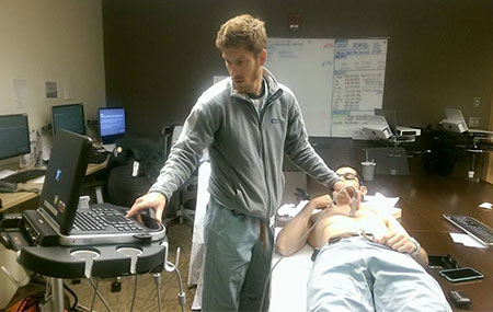 resident using radiology equipment while patient looks on